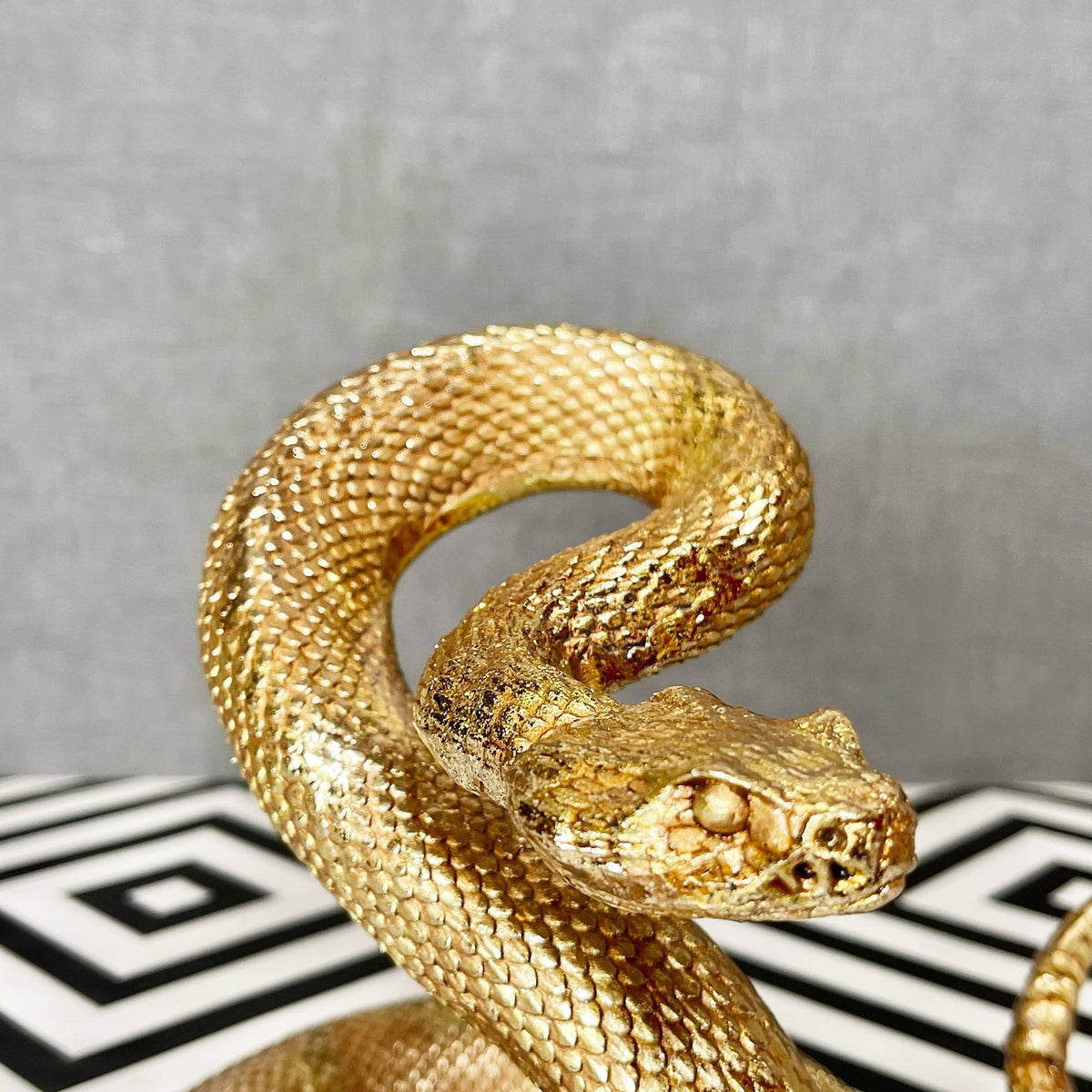 Ornamento serpente attorcigliato in resina dorata