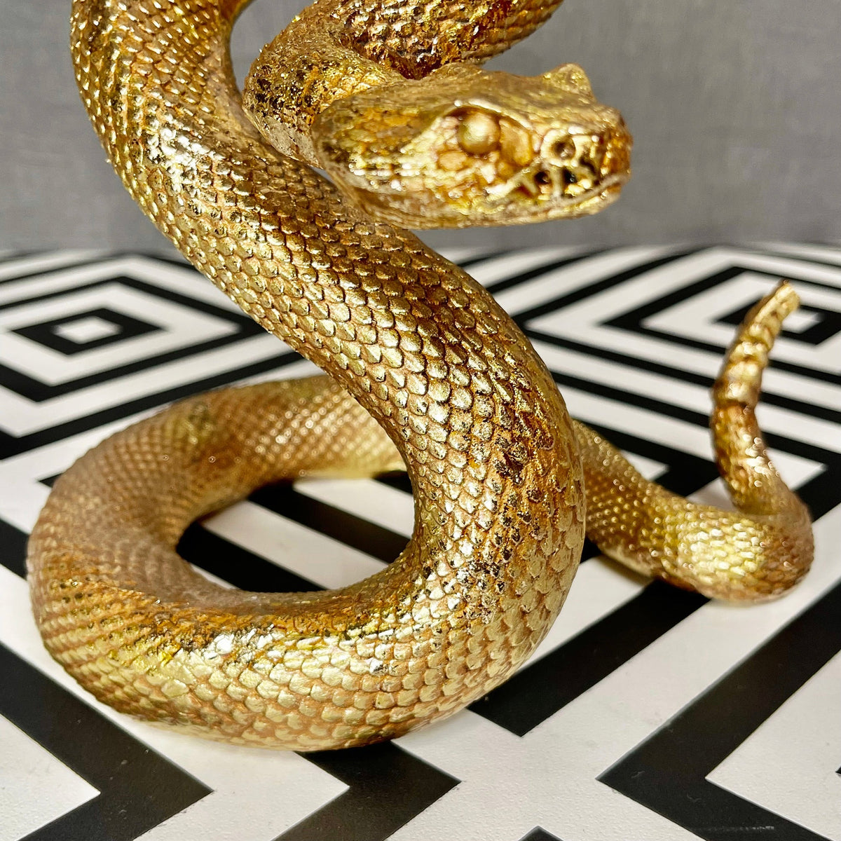 Ornamento serpente attorcigliato in resina dorata