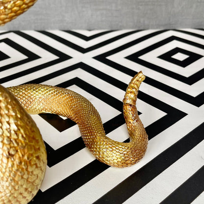 Ornamento serpente attorcigliato in resina dorata
