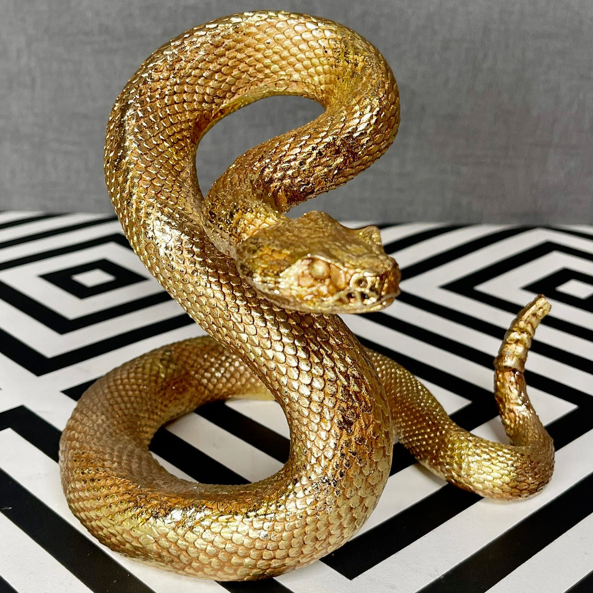Ornamento serpente attorcigliato in resina dorata